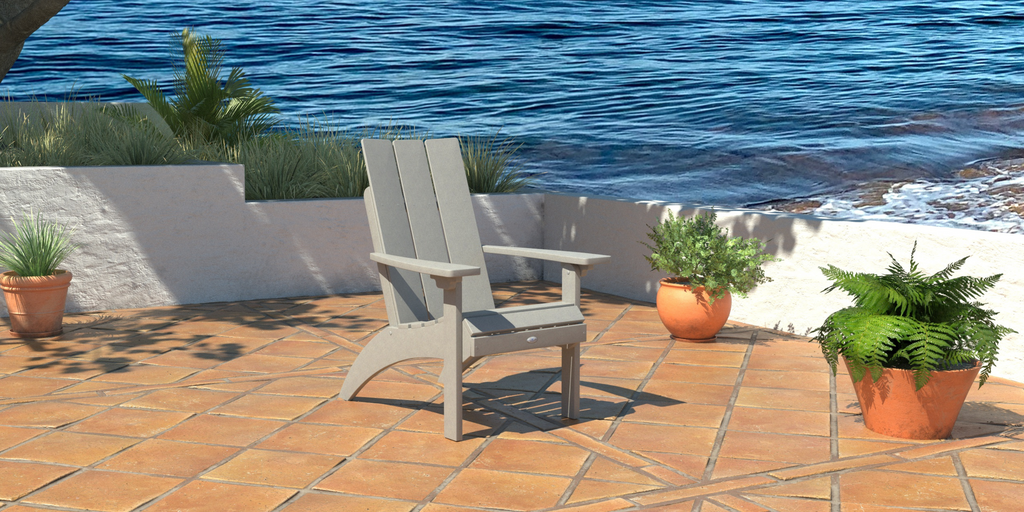 Cove Gray comfort height Adirondack chair on patio with water in the background 