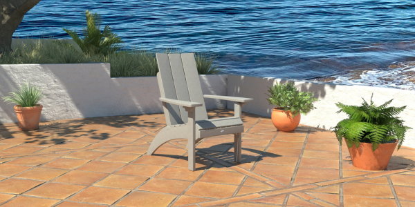 Gray Corolla comfort height Adirondack chair on patio with water in the background 