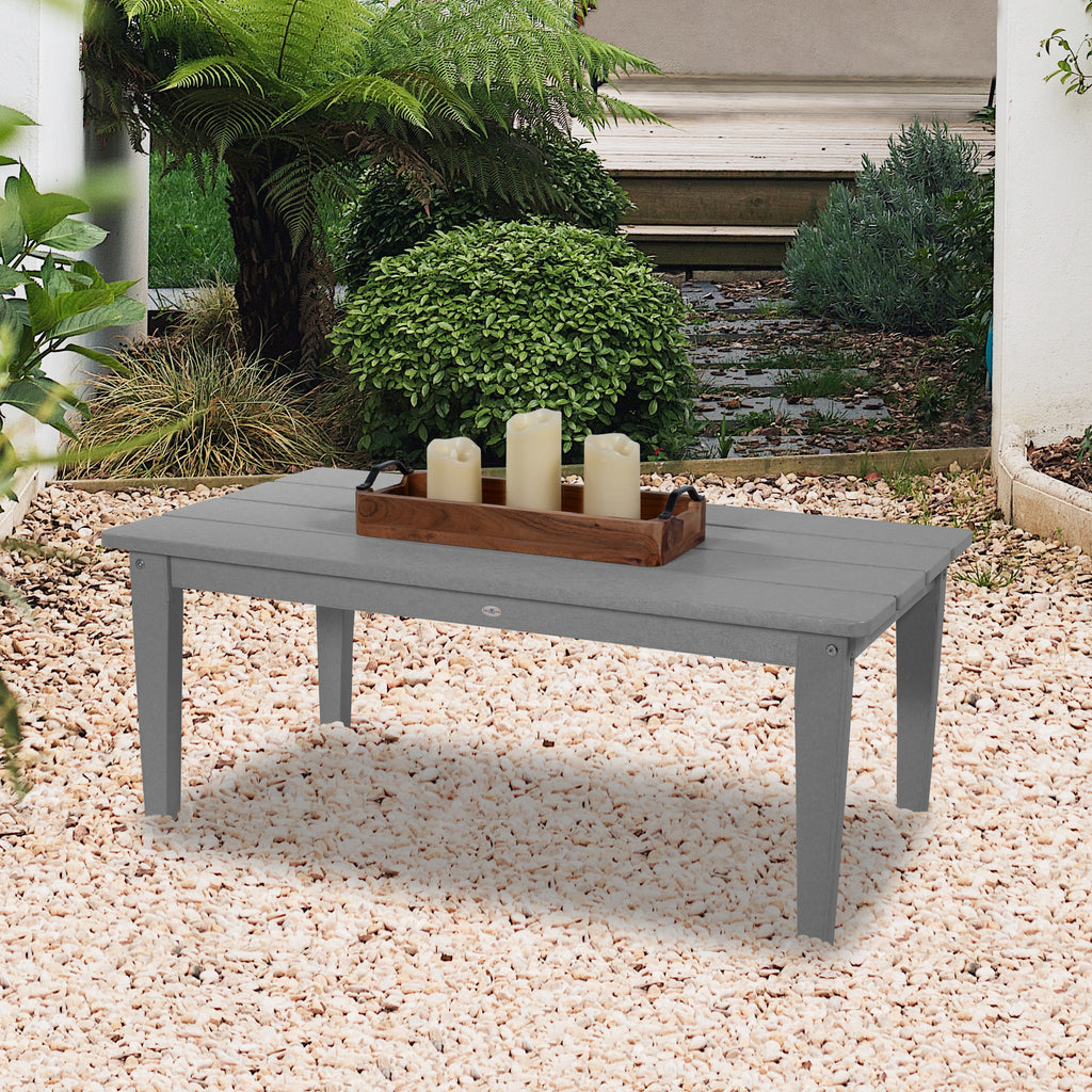 Gray Adirondack conversation table in white stone area with candles
