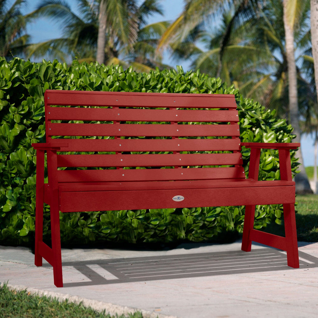 4ft Red Riverside garden bench with palm tree and bush background   