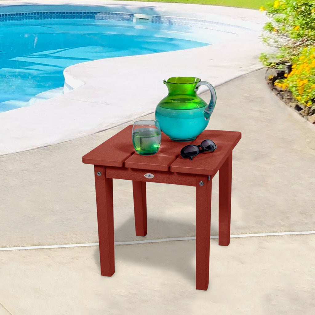 Small red side table with water pitcher and sunglasses