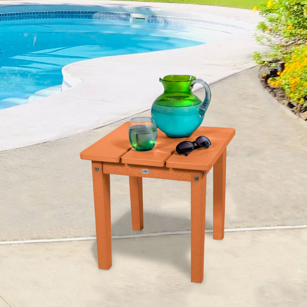 Small orange side table with water pitcher and sunglasses