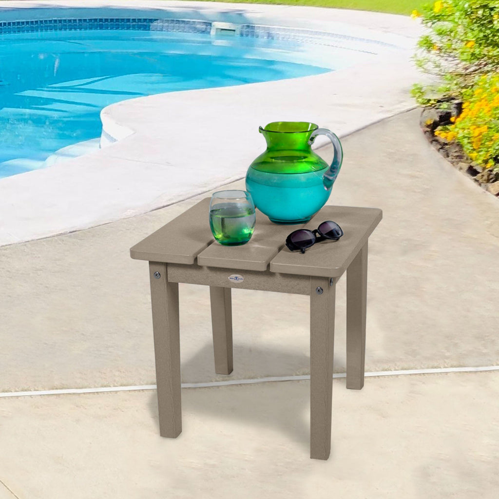 Small tan side table with water pitcher and sunglasses