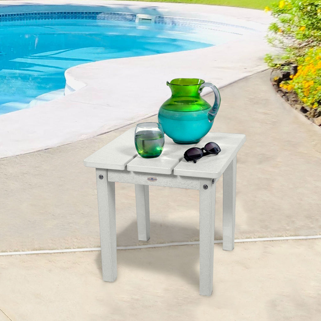Small white side table with water pitcher and sunglasses