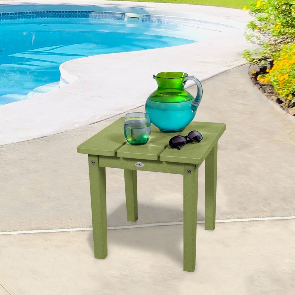 Small green side table with water pitcher and sunglasses