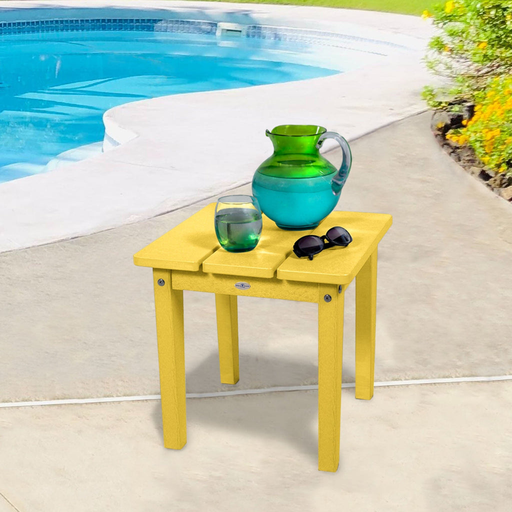 Small yellow side table with water pitcher and sunglasses