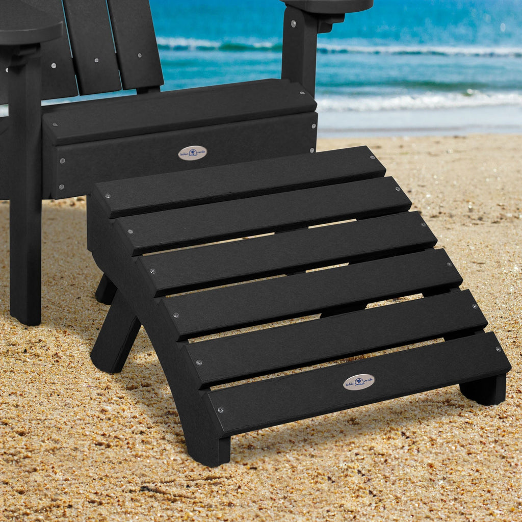Black Adirondack chair and folding ottoman on a beach 