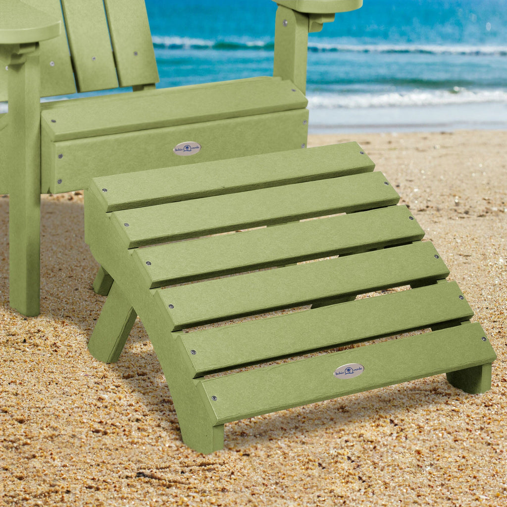 Green Adirondack chair and folding ottoman on a beach 