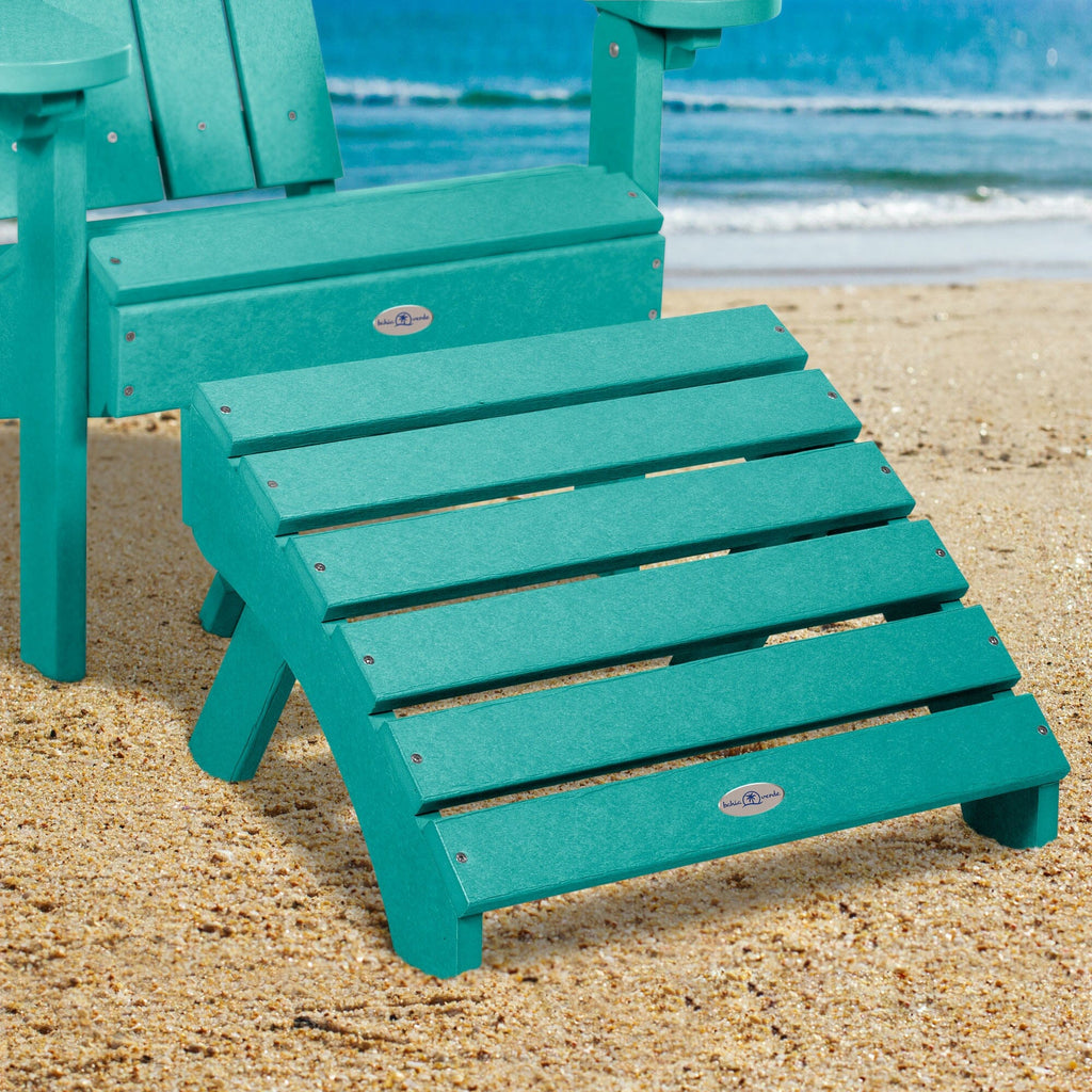 Blue Adirondack chair and folding ottoman on a beach 