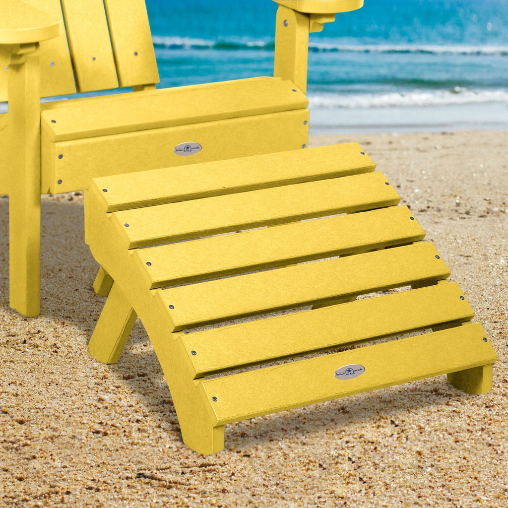 Yellow Adirondack chair and folding ottoman on a beach 