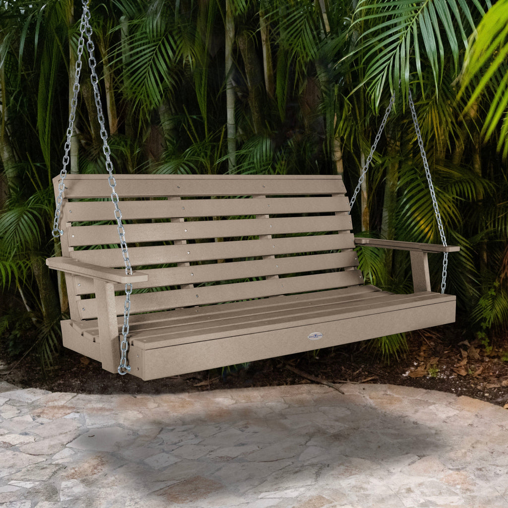 Tan porch swing with palm background