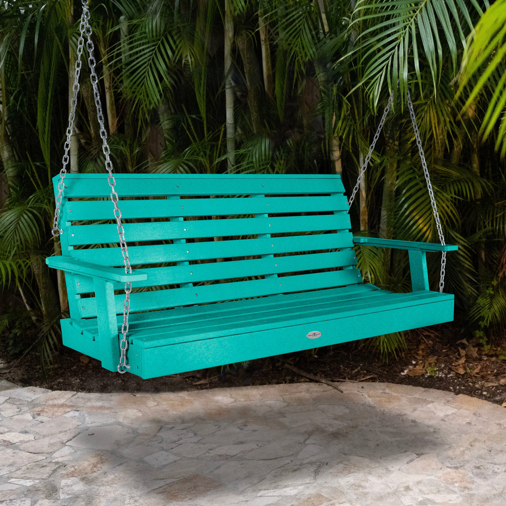 Blue porch swing with palm background